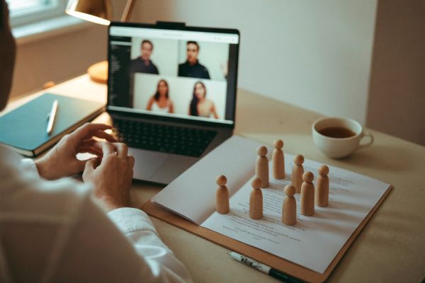 Laptop-Videokonferenz mit Aufstellungsfiguren auf dem Schreibtisch